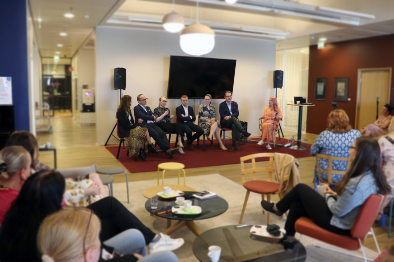 Varman johtajia puhumassa paneelikeskustelussa Olohuone-tilassa, varmalaisia seuraamassa keskustelua.