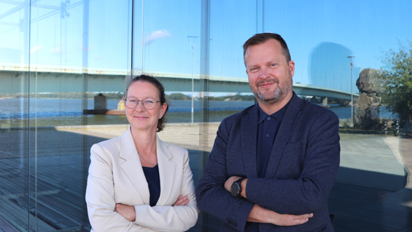 Kaksi henkilöä lasiseinän edessä